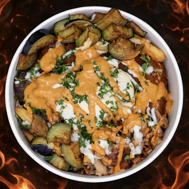 The Nar Grill West Side Bowl, top-down view — flaming kabob, chicken shawarma, roasted eggplant, garlic sauce, and spicy Nar X sauce